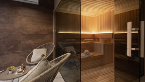 A modern bathroom with a wooden panel design, a glass partition, and a small seating area with chairs and a table.