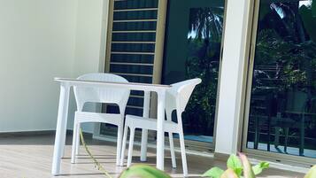 Relax in a tranquil outdoor space with a table and chairs overlooking a lush garden.