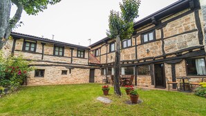 A stone building with a courtyard, outdoor seating, and potted plants.