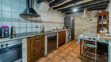 Una cocina con estufa, lavavajillas, pileta y alacenas de madera.