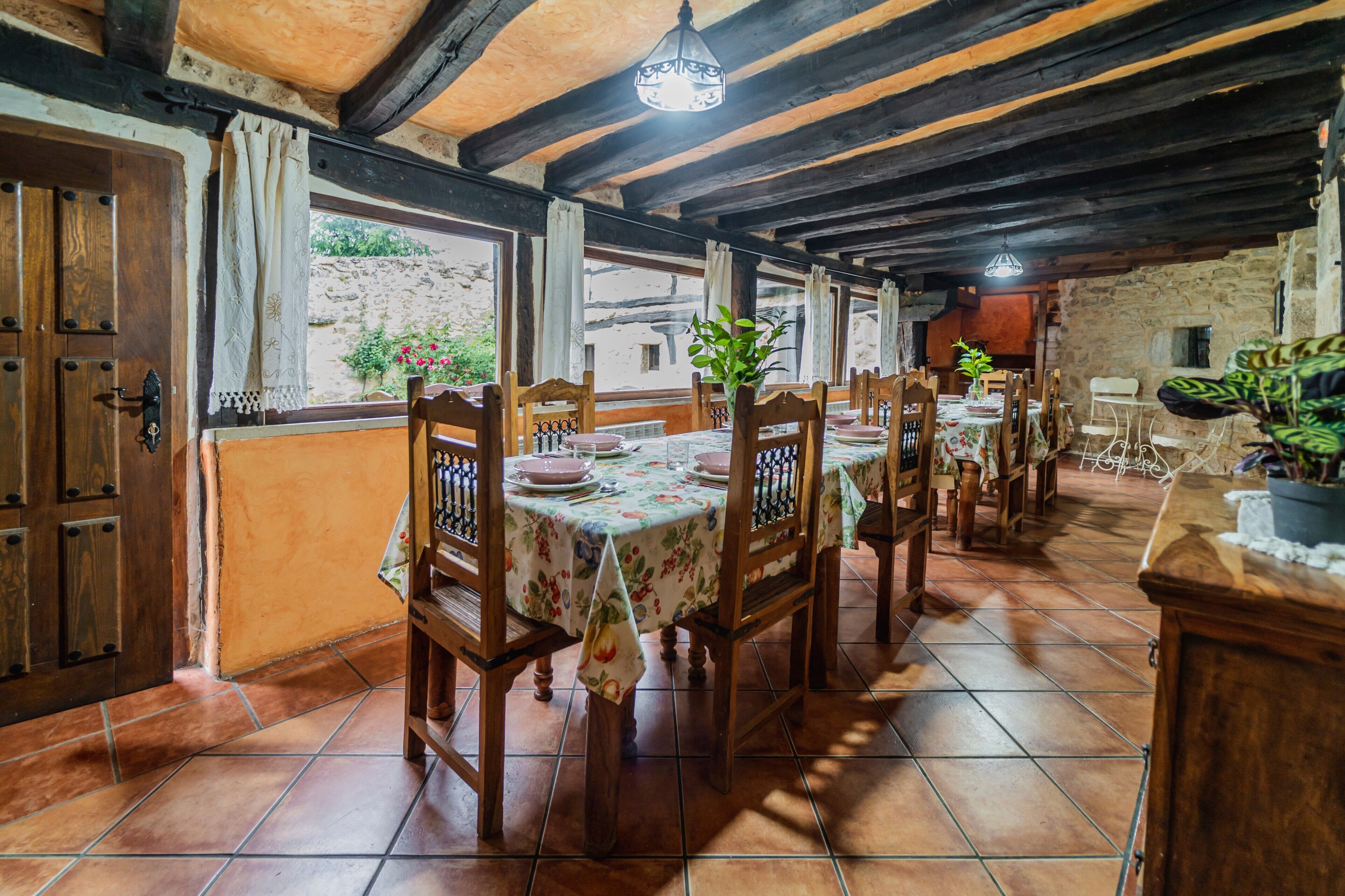 Un coin repas rustique, avec des meubles en bois, un sol carrelé et une vue par la fenêtre.