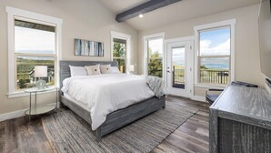 A bedroom with a large bed, a desk, and a balcony with a view. - Private Beach Access! Tennis/Pickleball Courts Nearby! Game Room! (Fish Haven)