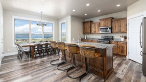 A spacious kitchen with wooden cabinets, a granite countertop, and a view of the outdoors. - Private Beach Access! Tennis/Pickleball Courts Nearby! Game Room! (Fish Haven)