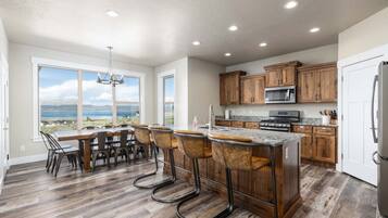 A spacious kitchen with wooden cabinets, a granite countertop, and a view of the outdoors.
