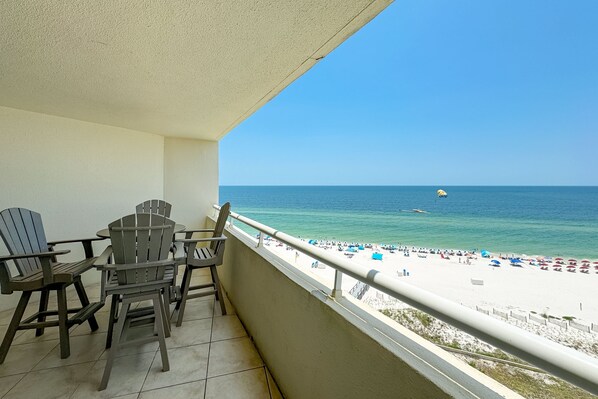 Un balcon avec des chaises donnant sur une plage.