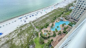 Un resort con playa, zona de piscina y un edificio de gran altura.