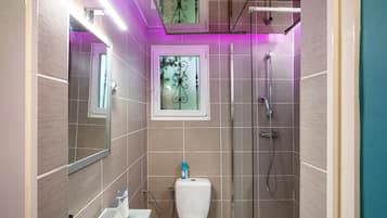 Ein modernes Badezimmer mit Duschkabine aus Glas, Toilette und Waschbecken.