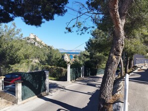 A paved pathway leading to a building with a view of a bridge and mountains. - Holiday Home 'Le Rove' with Air Conditioning, 600 m from Beach, Heart of the Calanques (Le Rove)