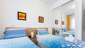 Ein Hotelzimmer mit zwei Betten, einem Spiegel und Bildern an den Wänden.