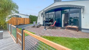 A modern house with a patio area featuring a table, chairs, and a small deck. - 2 bedroom beautiful home in Lemmer (Lemmer)