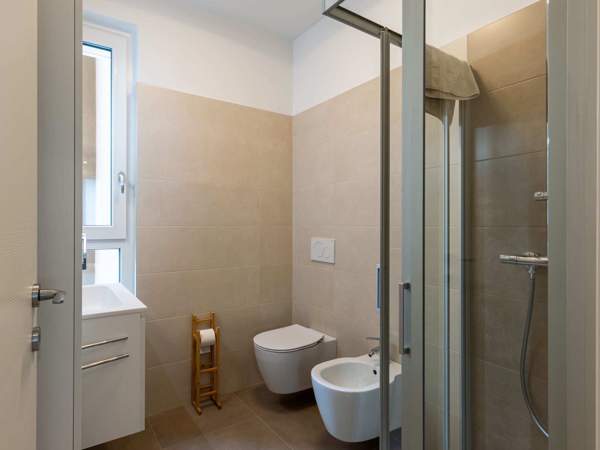 A modern bathroom with a toilet, bidet, and shower.