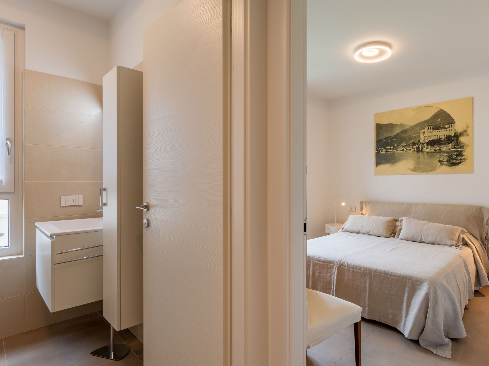 A bedroom with a bed, bedside table, and a painting on the wall.