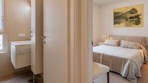 A bedroom with a bed, bedside table, and a painting on the wall. - Apartment Luna by Interhome (Gravedona)
