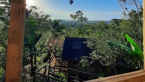 A wooden structure with a corrugated metal roof overlooking a lush landscape with a clear sky. - Chalé Tucano Eco.hospedagem - Virado Para o Nascer do Sol, com uma Vista Linda (Praia Grande)