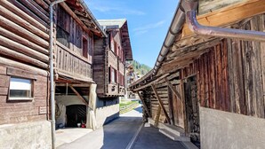 Une rue étroite bordée de bâtiments en bois dotés de balcons, sous un ciel dégagé.