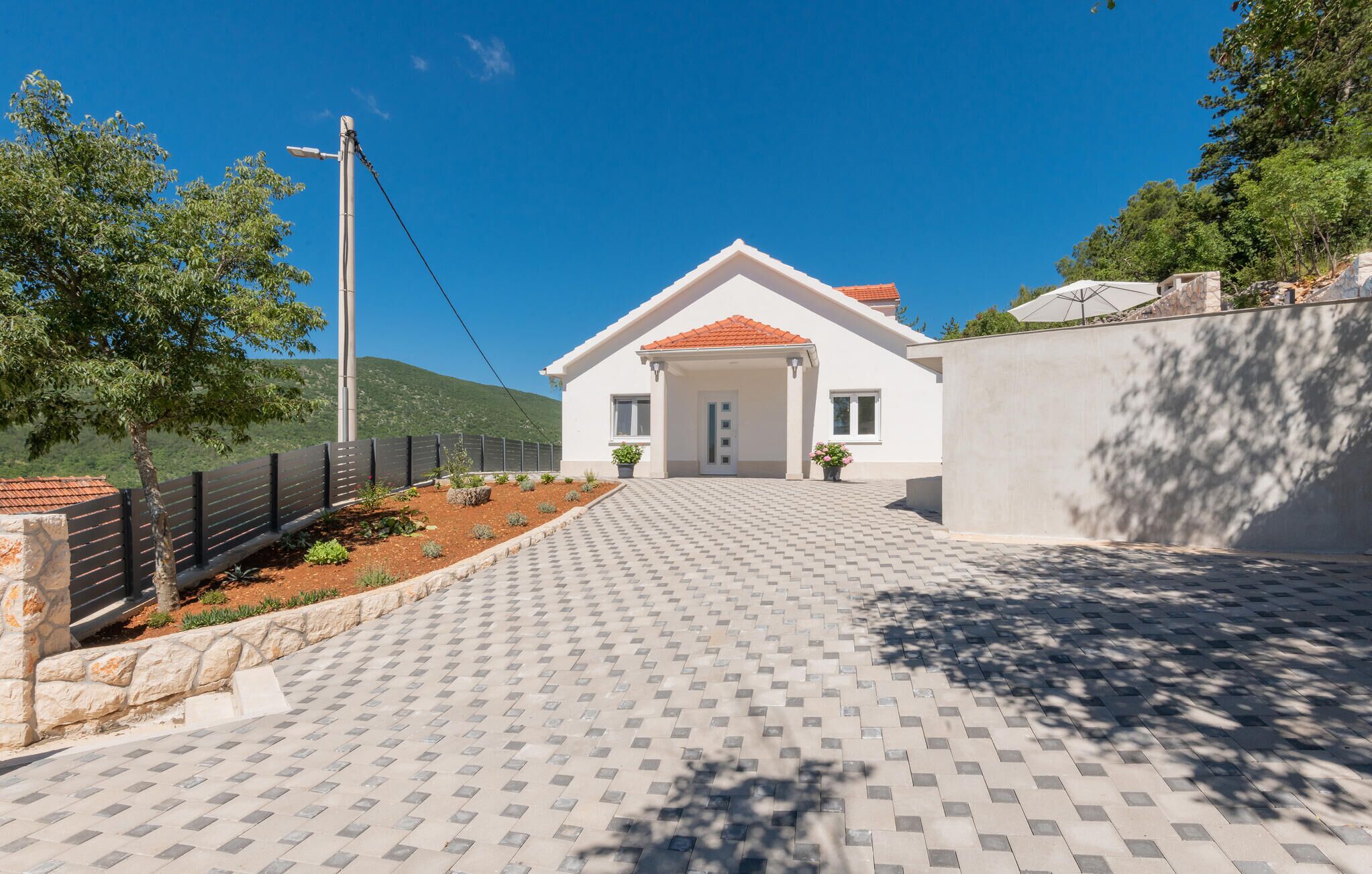 Una casa moderna con un camino empedrado que conduce a una entrada blanca.