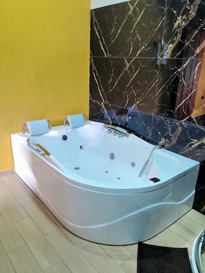 Ein modernes Badezimmer mit freistehender Badewanne, einer Marmorwand und einer gelben Akzentwand.