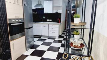 Een koelkast, een microgolfoven, kookgerei, borden en bestek