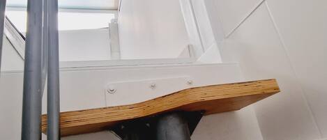 A staircase with a wooden handrail and metal support structure.