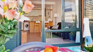 A modern kitchen with a washing machine, a dining area with a table and chairs, and a living room with a sofa and a TV. - Paraiso, 2 Bedroom, Terrace, wifi free (Playa Paraíso)