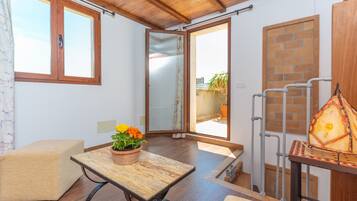 Een gezellige kamer met een houten tafel, een beklede bank en een bloempot.