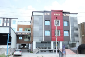 Un hotel a più piani con una facciata moderna, caratterizzato da una combinazione di colori rosso e grigio.