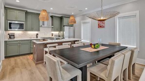 A modern kitchen with green cabinets, a central island, and pendant lighting. - Alto- Lrg Private Rooftop- Mins to Broadway & 12 S (Nashville)