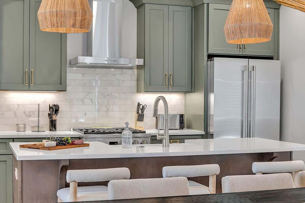 2nd Floor: Fully equipped kitchen stocked with all culinary essentials featuring stainless-steel appliances and a kitchen island offering ample counter space and bar seating.