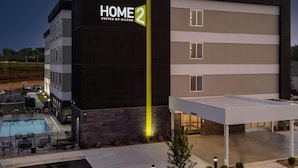 Un moderno edificio de hotel con un cartel que dice 'HOME 2 SUITES BY HILTON'.