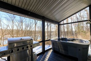 A covered outdoor area with a barbecue grill and a hot tub. - Scenic New Paltz Escape: River Views, Hot Tub & Deck | Dream House in the Gunks (New Paltz)