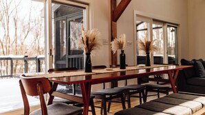 A dining area with a wooden table, chairs, and vases with pampas grass. - Scenic New Paltz Escape: River Views, Hot Tub & Deck | Dream House in the Gunks (New Paltz)