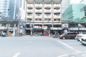 Um edifício de vários andares com estabelecimentos comerciais no andar térreo, incluindo uma lavanderia e uma padaria.
