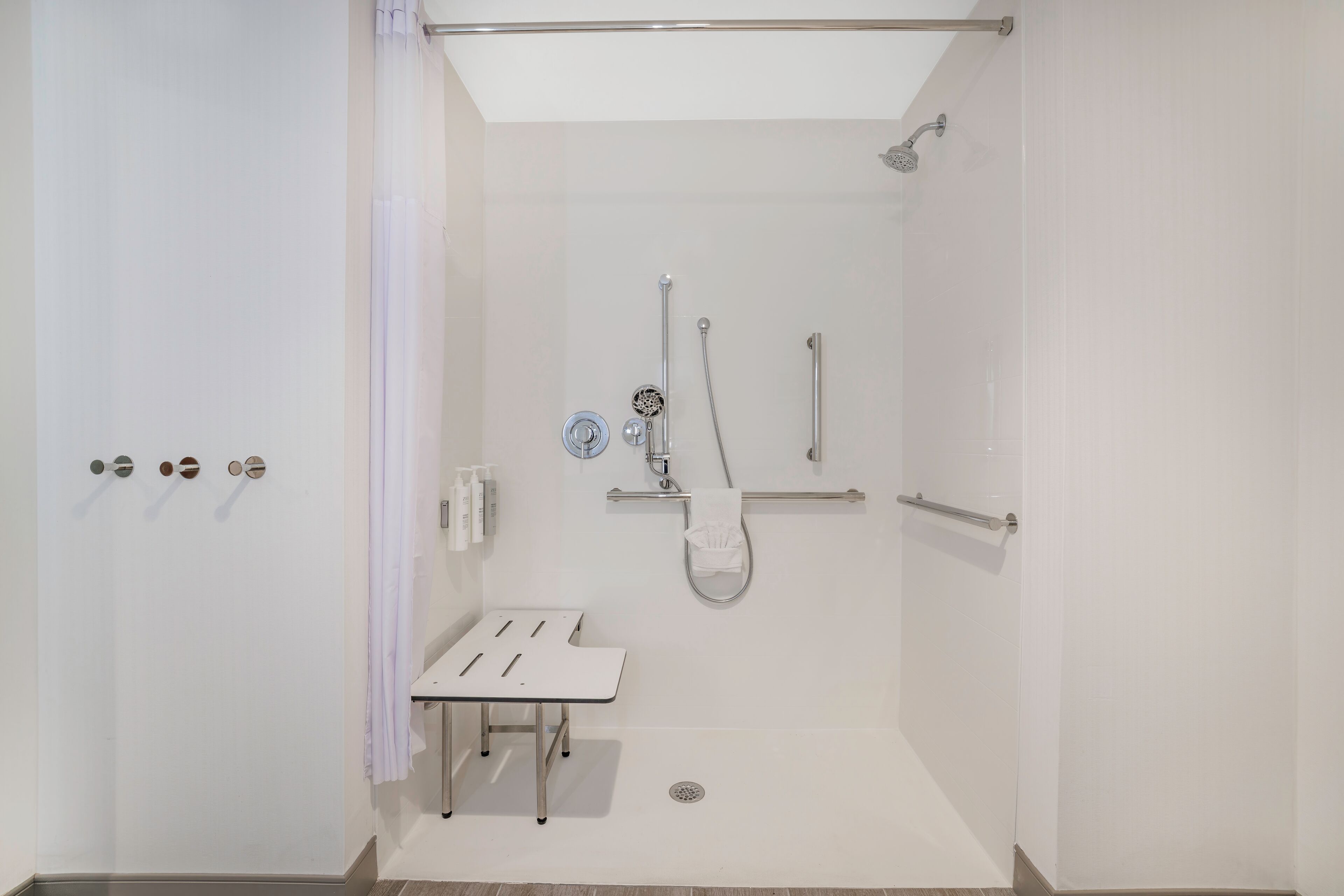 A modern bathroom with a shower, a toilet, and a sink.