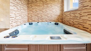 Un jacuzzi con panel de control, rodeado de paneles de madera y una ventana.