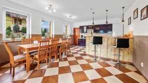 Una cocina amplia con piso de tablones, mobiliario de madera y una barra.