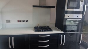 A compact kitchen with a gas stove, a microwave, and a built-in oven.