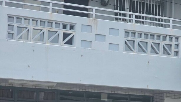 A building with a glass entrance, a sign reading "Guest house cocode.", and a metal railing in front. - Guest house cocode. - Hostel (Ishigaki)