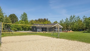 A beach volleyball court with a net, a small building, and a grassy area with trees in the background. - "Ahto" - 600m to the fjord by Interhome (Højslev)