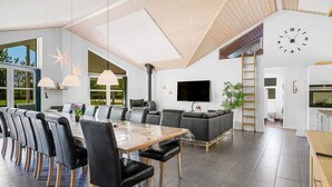 A modern kitchen with a built-in oven, a large window, and a clock on the wall. - "Ahto" - 600m to the fjord by Interhome (Højslev)