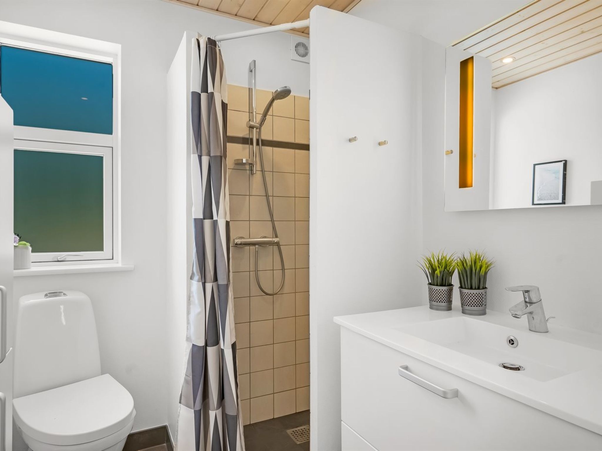 Une salle de bain moderne équipée d’une douche, de toilettes et d’un lavabo.