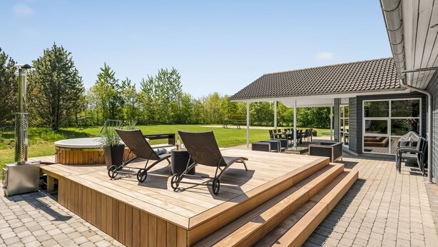 A wooden deck with outdoor furniture, a hot tub, and a covered patio area. - "Ahto" - 600m to the fjord by Interhome (Højslev)