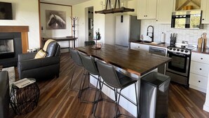Eine moderne Küche mit Kochinsel, Edelstahlgeräten und einem Essbereich mit Ledersofa.