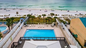 Ein Poolbereich mit Blick auf Strand und Meer.