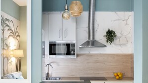 A modern kitchen with a built-in microwave, stainless steel range hood, and a wooden countertop. - Sevillian Charm on Sol street - Comfort and Tradition 5 Min from Las Setas (Sevilla)