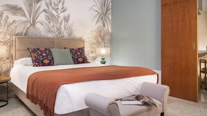 A bedroom with a bed, a nightstand, a lamp, a wooden wardrobe, and a chair. - Sevillian Charm on Sol street - Comfort and Tradition 5 Min from Las Setas (Sevilla)