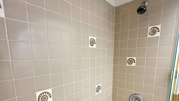 A bathroom with a bathtub, a shower, and a toilet. - Kanai a Nalu Unit 204 Oceanfront Corner Unit- New rate for Summer (Wailuku)