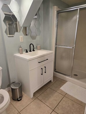 A modern bathroom with a white sink, black faucet, and a shower with a glass door. - The Port - Walkable to University of Florida, includes Parking (Gainesville)