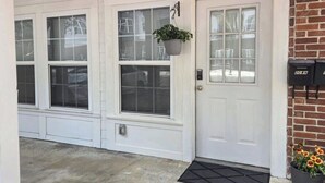 A front door with a mailbox, a hanging planter, and a potted plant with flowers. - The Port - Walkable to University of Florida, includes Parking (Gainesville)