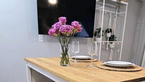 A kitchen with a wooden countertop, a TV mounted above, and a shelf with kitchenware. - The Port - Walkable to University of Florida, includes Parking (Gainesville)