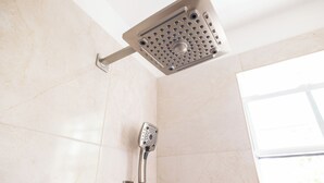 A modern bathroom with a shower head and a handheld shower attachment. - Hilltop View: Convenient & Peaceful Studio Haven (Cedar Valley Mill Road)